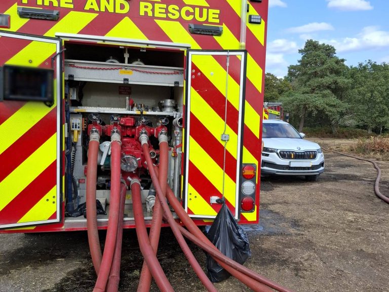 Photo taken at the New Forest wildfire, from the rear of a fire engine, showing the pumping equipment with multiple hoses extending from the pump.